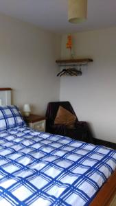 a bedroom with a blue comforter on a bed at Room with a view in Killarney