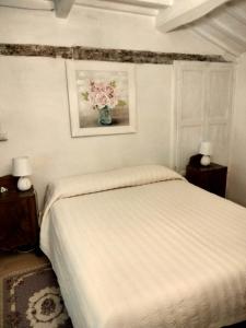 Un dormitorio con una cama con un jarrón de flores en Il giardino dei sogni, en Montefortino