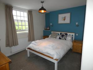 a bedroom with a bed with blue walls and a window at The Sloop Inn in Kingsbridge