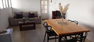 ein Wohnzimmer mit einem Tisch und einem Sofa in der Unterkunft Departamentos Parque Lineal in San Salvador de Jujuy