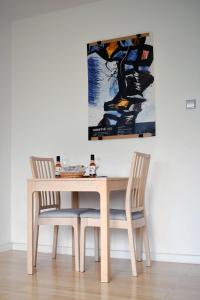 een eettafel met 2 stoelen en een schilderij bij Cozy donkey - sporty lake apartment in Zagreb