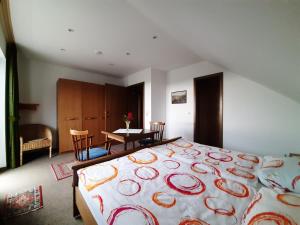 a bedroom with a large bed and a table with chairs at Haus - Pantenburg in Manderscheid