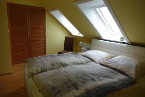 a bedroom with a bed with two pillows and two windows at Grüne Düne Meerblick Friedrichskoog Spitze in Friedrichskoog