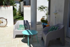 twee stoelen en een tafel op een patio bij Atlantic Hôtel in Saint-Pierre-dʼOléron