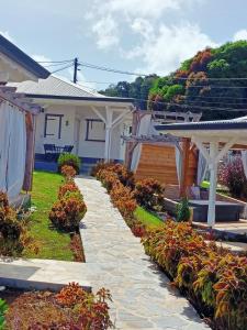 a house with a stone walkway in the yard at O'Parad'îles in Goyave