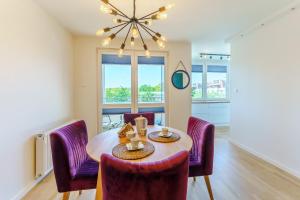 a dining room with a table and purple chairs at SUN 7 - osiedle JANTAR in Kołobrzeg