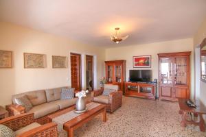 sala de estar con sofá y TV en Villa con piscina y vistas al mar - Mar 27 H, en Calpe