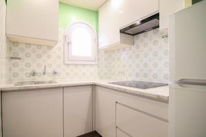 eine weiße Küche mit einem Waschbecken und einem Fenster in der Unterkunft Villa con piscina y vistas al mar - Mar 27 H in Calpe
