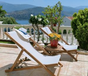zwei Stühle und ein Hut auf einer Terrasse in der Unterkunft Blue Lagoon Luxury Apartment G2 in Argostoli
