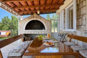 patio con tavolo e camino in pietra di Bay View House a Zaton