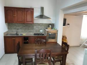 a kitchen with a wooden table with chairs and a sink at Vacanze Fuori Porta in Grottaglie