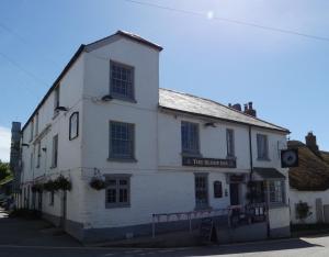 a white building on the corner of a street at The Sloop Inn in Kingsbridge
