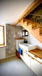 uma cozinha com um lavatório branco e uma escadaria em Gîte de l'école em Romagnat