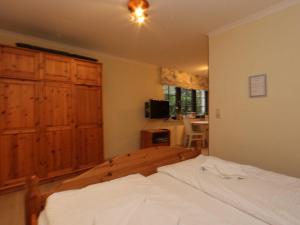 a bedroom with a bed and a wooden cabinet at Ferienwohnungen Finja strandnah in Zinnowitz Fewo cc in Zinnowitz