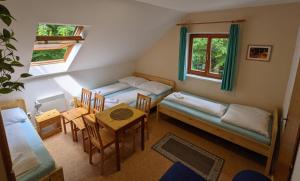 a small room with two beds and a table at Penzion Jezero in Vranov nad Dyjí
