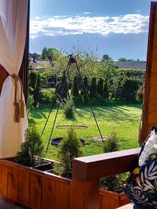 a window with a view of a garden with a camera at Całoroczny dom w sercu Mazur in Węgorzewo