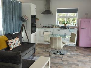 een woonkamer met een bank en een tafel en een keuken bij Bunlin Heights Self Catering Studio in Milford
