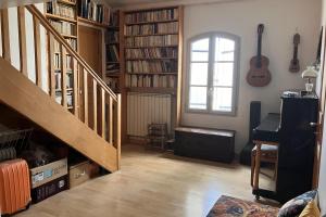 salon z klatką schodową, fortepianem i oknem w obiekcie Superb 90m With Wifi Located In Avignon! w Awinionie