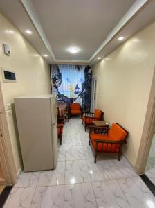 Villa 29 - Marouf Group في رأس البر: غرفة بها كراسي وطاولات ونافذة كبيرة