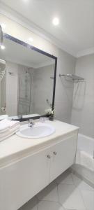 bagno bianco con lavandino e specchio di Quiet 2 bedroom apartment-Sleeps up to 6 a Mijas