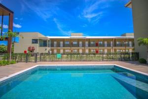 博尼图Promenade Bonito All Suites的建筑物前的游泳池
