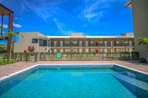 a swimming pool in front of a building at Promenade Bonito All Suites in Bonito