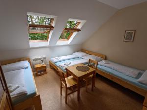 a room with two beds and a table in it at Penzion Jezero in Vranov nad Dyjí