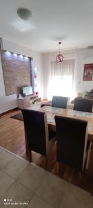 Vrnjačka BanjaにあるAlex apartmanのテーブルと椅子のあるリビングルーム