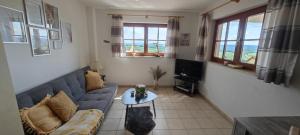 a living room with a couch and a tv at Ferienwohnung Look wide in Oberelsbach