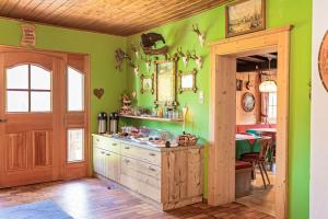 a kitchen with green walls and a wooden door at Lohningbauer in Maria Alm am Steinernen Meer