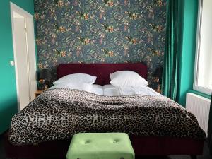 1 dormitorio con 1 cama y papel pintado con motivos florales en SmartHotel Flamingo Self check-in en Gießen