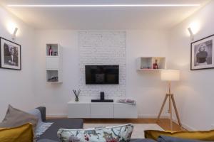 sala de estar con sofá y TV en una pared blanca en Castaldi 18 - Milano in tasca en Milán