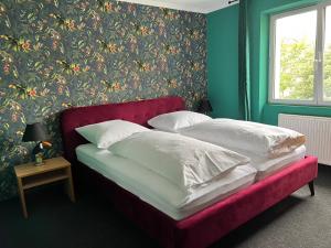 two beds in a bedroom with a floral wallpaper at SmartHotel Flamingo Self check-in in Gießen