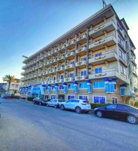 un gran edificio con coches estacionados frente a él en Dolphin Ras El-Bar Hotel, en Ras El Bar