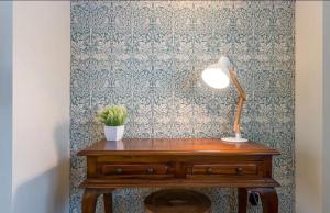 a table with a lamp and a potted plant on it at Stunning 2 bed Cottage in Saddleworth in Dobcross