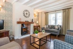 a living room with a couch and a fireplace at Stunning 2 bed Cottage in Saddleworth in Dobcross