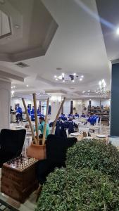 a room with tables and chairs and a room with plants at Univers Resort in Elbasan