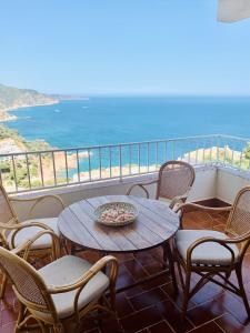 een tafel en stoelen op een balkon met uitzicht op de oceaan bij Finestra del Mar in Cañet de Mar