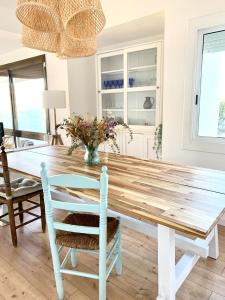 een eetkamer met een houten tafel en stoelen bij Finestra del Mar in Cañet de Mar