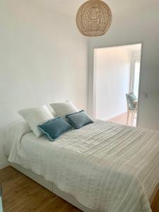 - un lit blanc avec 2 oreillers bleus dans l'établissement Finestra del Mar, à Cañet de Mar