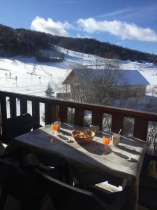 una mesa en un balcón con vistas a una pista de esquí en Appart très ensoleillé 5-6 pers au pied des pistes, en Ancelle