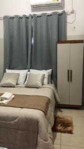 1 dormitorio con 1 cama con cortina azul en Ágape Hotel, en Rio Verde