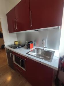 a kitchen with red cabinets and a sink at Andaleppo in Mestre