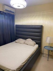 Los CasabesにあるLesnah Apartamento, Jacobo Majlutaの青いヘッドボードとテーブルが付いたベッドのある寝室