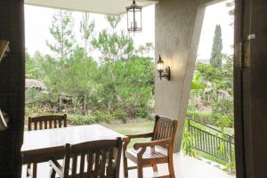 une terrasse couverte avec une table et des chaises et une vue sur le jardin dans l'établissement VILLA BATU Luxurious privacy 3BR villa@ klub bunga, à Batu