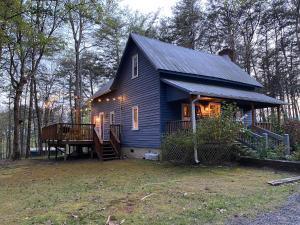 ein blaues Haus mit einer Veranda und einer Terrasse in der Unterkunft Romantic, Secluded Historic Cottage on 5 Acres 30 mins to TIEC in Landrum