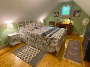 a bedroom with a bed and a table and a window at Romantic, Secluded Historic Cottage on 5 Acres 30 mins to TIEC in Landrum