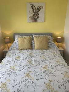 a bed with a white comforter with a rabbit on it at Chalet 26 Widemouth Bay in Bude