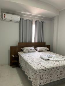 a bedroom with a bed with a white comforter at Pousada Sertaneja in Canindé de São Francisco