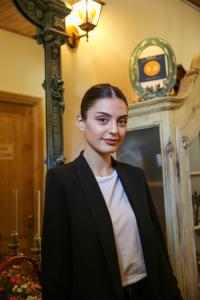 a woman standing in a room wearing a suit at Vintage Art Rooms in Tbilisi City